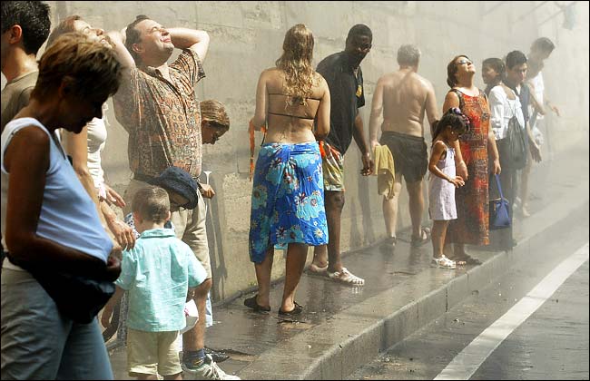 People cooled down by water jets along the banks of the Seine, Paris, August 9, 2003.