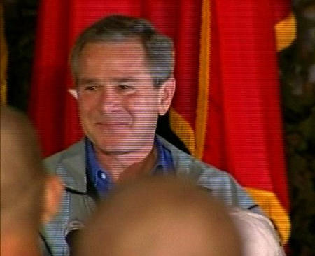 U.S. President George W. Bush drops a tear in this image from TV as he takes to the stage to address U.S. soldiers upon his surprise arrival for Thanksgiving at a military base at Baghdad International Airport, November 27, 2003.