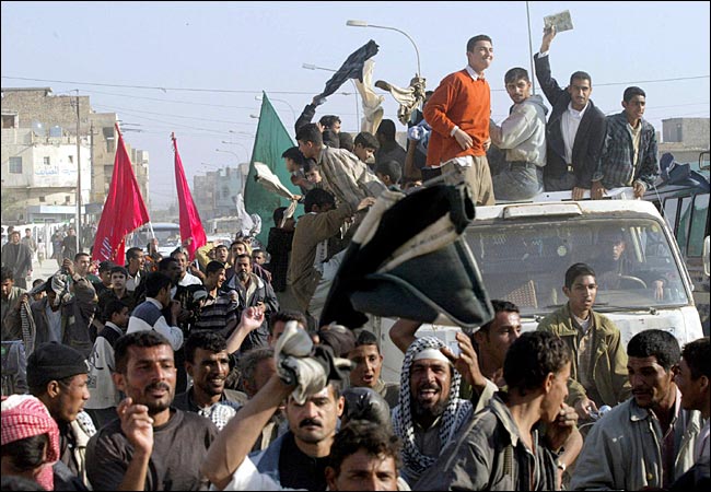Iraqis danced in the streets of Baghdad after hearing the news of Saddam Hussein's capture, on which they said they had not seen such celebrations in the streets since the end in the late 1980's of the disastrous Iran-Iraq War, December 14, 2003.