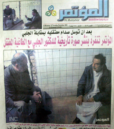 The front page of Al-Moutamar newspaper which shows a picture of captivated Saddam Hussein sitting on the floor across from Ahmed Chalabi, a member of Iraq's American-picked Governing Council, was published in Baghdad, December 18, 2003.