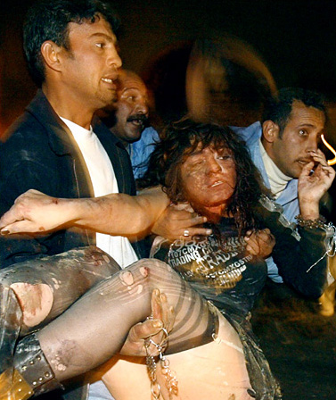 A woman injured in the blast at Nabil restaurant in Baghdad was carried away by Iraqi police officers, late December 31, 2003.