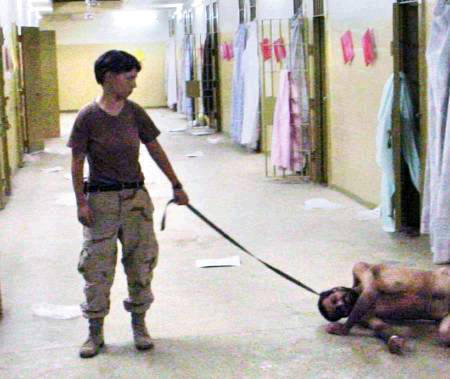 A woman identified as Private Lynndie R. England of the 372nd Military Police Company, an Army Reserve unit based in Cresaptown, Md., holds what appears to be a dog's leash around the neck of a naked man at the Abu Ghraib prison in this undated photo published in The Washington Post on May 6, 2004.