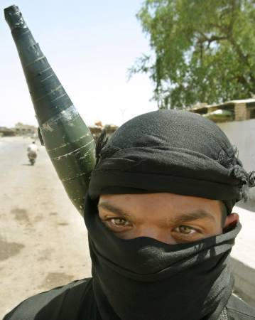 An Iraqi Shi'ite militiaman, armed with an RPG (rocket-propelled grenade), patrols in the holy city of Najaf, May 25, 2004.