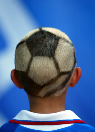 A young Russia team fan sports a painted head as he looks on before the start of the Euro 2004 Group A Euro 2004 soccer match at the Luz Stadium, Lisbon, June 16, 2004.