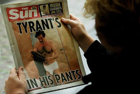 A man reads the British tabloid newspaper The Sun carrying a front page picture showing imprisoned former Iraqi leader Saddam Hussein in his underwear, London May 20, 2005.