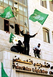 After winning elections, Hamas supporters raise flags and guns over the Palestinian parliament, Ramallah, January 26, 2006.