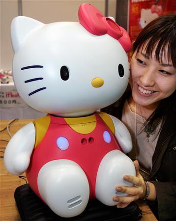 A Japanese woman smiles next to Hello Kitty Robo, developed by Japanese robot maker Business Design Laboratory, at the 2005 International Robot Exhibition, Tokyo, November 30, 2005.