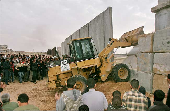 Hundreds of Palestinians stream into Egypt after militants with bulldozers broke through a border wall in Gaza and opened fire that killed at least 2 Egyptian soldiers, January 4, 2006.