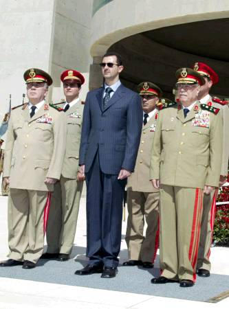 Syrian president Bashar al-Asad, Defence Minister Mustafa Tlas (R) and Chief of Staff Hassan Turkmani (L) attend a ceremony at the anonymous soldier monument to mark the 30th anniversary of the 1973 Middle East war, October 6, 2003.