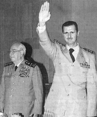 Syrian president Bashar al-Asad and Defence Minister Mustafa Tlas attend a ceremony on Syrian Army Day, August 1, 2003.