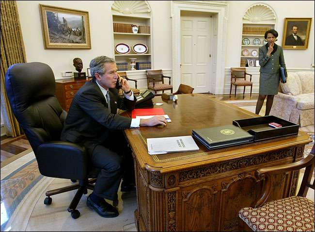 U.S. President George W. Bush talks with a key ally on Iraq, Prime Minister Jos María Aznar of Spain, as Ms. Condoleezza Rice standing by, March 2003.