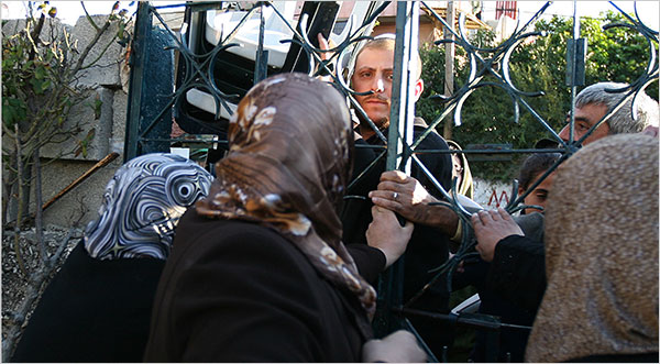 Palestinian women try to hold a gate to a home closed as Jewish nationalists who had taken over the house by court order came to move into the property, December 1, 2009.