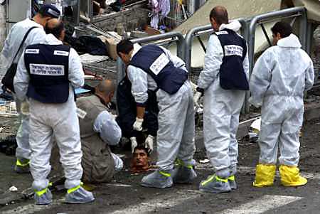 Israeli policemen inspect a head of a Palestinian suicide bomber, Jerusalem, March 21, 2002.