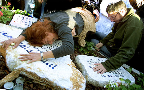 A memorial service for a mother and two children killed in an attack on Kibbutz Metzer, Israel, December 16, 2002. The killings were on November 11.