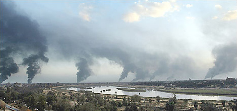 Black smoke billowed over Baghdad Thursday as the Iraqis set fire to oil-filled trenches in an effort block the visibility of American warplanes, March 27, 2003.