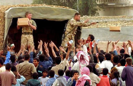 Soldiers of the British Army's Light Infantry and 2nd Royal Tank Regiment distribute aid and food packages to local people in AzZubayr, near Basra, March 27, 2003.
