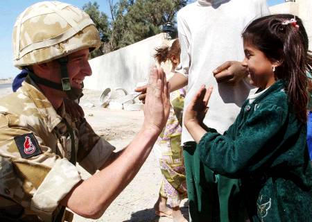 A Desert Rat playing with an Iraqi girl, April 2, 2003.