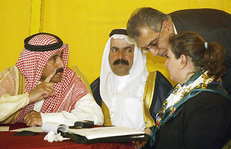 Maha A-Shaibib Joudi, member of the opposition group Project for the Future of Iraq, Zalmay Khalilzad, the president's special envoy to the Iraqi opposition, speak to two Iraqi representatives at a meeting on remaking the country, Ur, Iraq, April 15, 2003.
