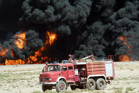 A fire truck is parked at the scene of the second of two ferocious blazes raged out of control along the oil pipeline, near Baiji, northern Iraq, August 17, 2003.