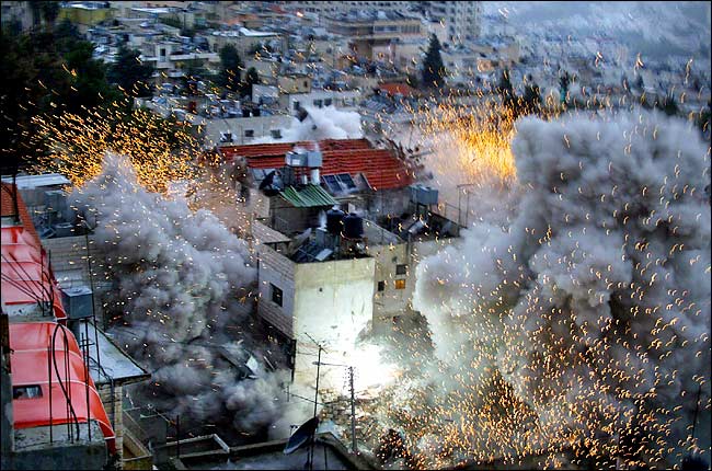 The Israeli Army blew up a Palestinian house during a standoff with a wanted Palestinian militant, Nablus, January 22, 2004.