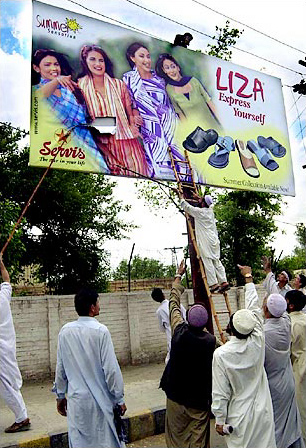 In Peshawar, Pakistan, posters with women's faces were removed from billboards after the provincial government was taken over by hard-line Islamists, May 2003.