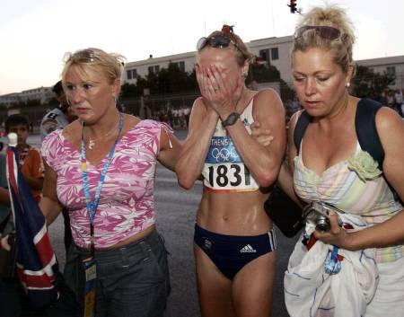 Britain's Paula Radcliffe is helped by two British spectators after pulling out of the women's marathon in Athens 2004 Olympic Games, Athens, Greece, August 22, 2004.