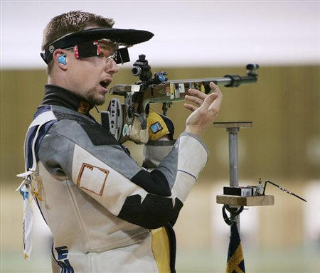 USA's Matthew Emmons signals to officials that he fired his gun during the final round of the men's 50m rifle 3 position finals, but instead of aiming at his target, he fired at another competitor's target (an error sent the marksman from a first place gold medal to last), at the 2004 Summer Olympics, Athens, Greece, August 22, 2004.