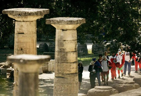 Women shot-putters walk past the ruins of the site of the ancient olympics, used for Olympic competition for the first time in nearly 16 centuries, prior to their final competition in the 2004 Athens Olympic Games, Ancient Olympia, Greece, August 18, 2004.