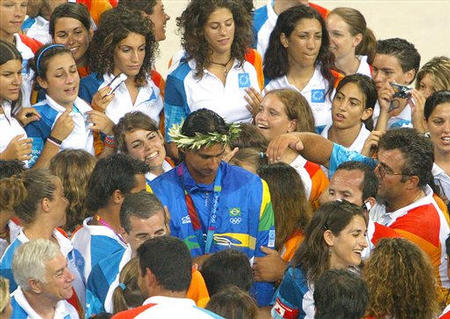 Brazil's Ricardo Santos signs autographs for the staff after he and his teammate Emanuel Rego beat Spain's Pablo Herrera and Javier Bosma in the gold medal match at the 2004 Olympic Games in the Olympic Beach Volleyball Centre, Athens, Greece, August 25, 2004
