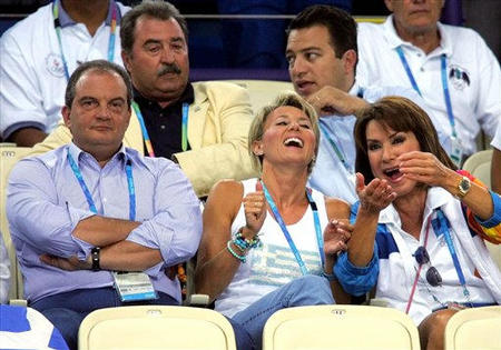 Greece's Prime Minister Constantinos Karamanlis, left, watches the Greek team play volleyball against Argentina as his wife Natasha, center, jokes with Gianna Angelopoulos, the President of the Athens 2004 Olympic Committee, at the 2004 Olympic Games, Athens, August 19, 2004.