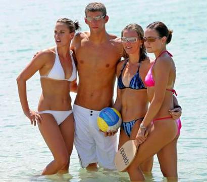 Swimmers from the United States Amanda Beard, Michael Phelps, Jenny Thompson and Natalie Coughlin gather for a group photo on a beach while participating in a Speedo sponsored event in Athens, August 24, 2004.