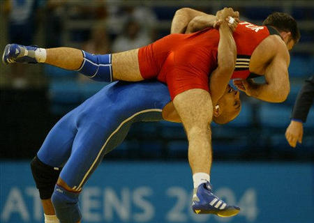 Egypt's Karam Gaber Ibrahim, bottom, fights with Turkey's Mehmet Ozal in the men's Greco-Roman 96kg semi-finals at the Olympic Games in Athens, August 26, 2004.
