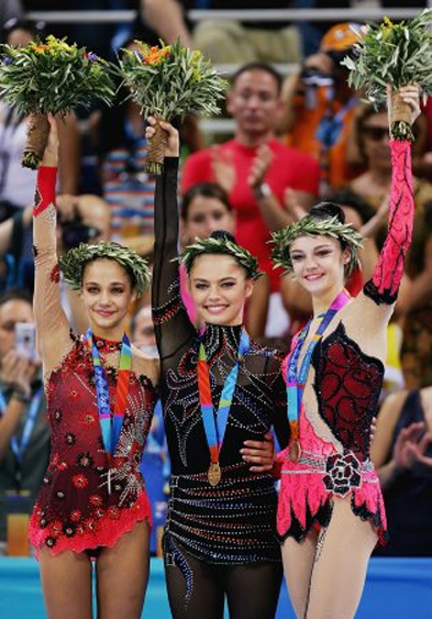 Alina Kabaeva of Russia, center, who won the gold medal, waves with silver-medalist Irina Tchachina of Russia, left, and bronze-medalist Anna Bessonova of Ukraine, right, during the medal ceremony for the rhythmic gymnastics individual all-around at the 2004 Olympic Games in Athens, Greece, August 29, 2004.