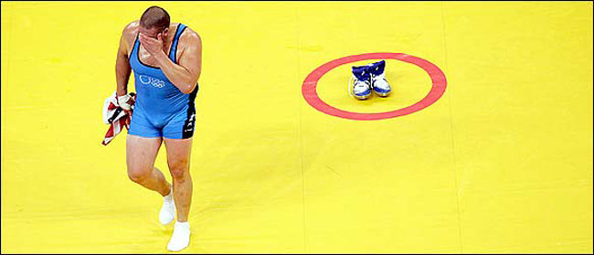 Rulon Gardner of the United States leaves his shoes in the center of the mat, a tradition that symbolizes the end of a career, after defeating Sajad Barzi of Iran, and winning men's Greco-Roman 120 kg wrestling bronze medal bout at the 2004 Olympic Games in Athens, Greece, August 25, 2004.