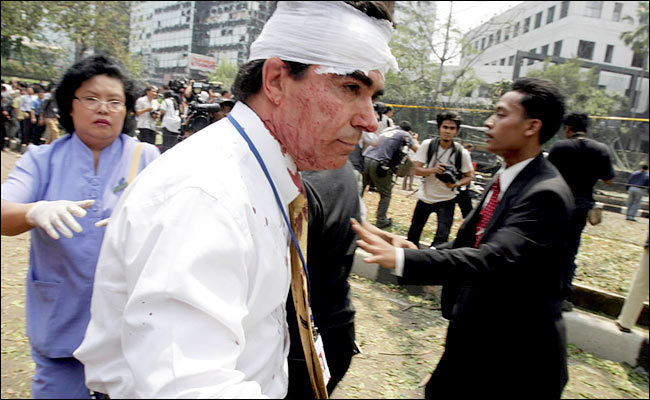 An injured worker is treated outside the Australian embassy after an Islamic bombing, Jakarta, September 9, 2004.