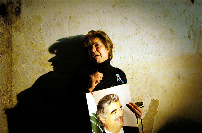 Jumana Tabara, a Lebanese woman, weeps and holds a portrait of former Prime Minister Rafiq Al-Hariri in a building used by the Syrian intelligence services, after she watched from her home across the street as the Syrians packed up and left, and then rushed over, taking the portrait along, mid March 2005.