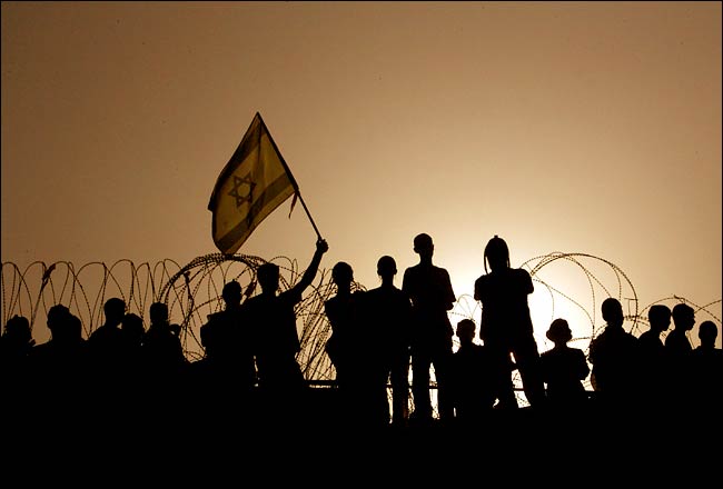 Hundreds of protesters on the synagogue roof barricade themselves behind rows of barbed wire, Kfar Darom, Gaza, August 18, 2005.