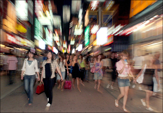Waves of teenagers, mostly female, in downtown Shibuya at night, Central Tokyo, September 2005.