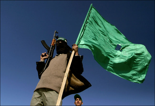 After winning elections, a Hamas militant waves his party's flag  in the southern Gaza Strip refugee camp of Khan Younis, January 26, 2006.