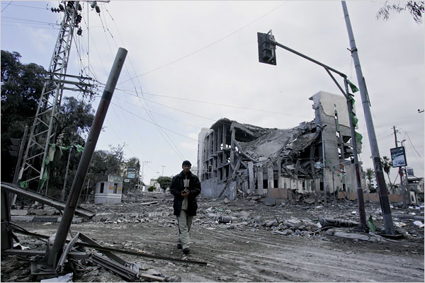 On the sixth day of Israel’s massive attack on Hamas sites throughout Gaza in retaliation for the recent rocket fire from the area, a man walks by the destroyed Parliament building, Gaza City, January 1, 2009.