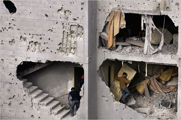 On the seventh day of Israel’s massive attack on Hamas sites throughout Gaza in retaliation for the recent rocket fire from the area, Palestinians collect belongings from the destroyed home of killed Hamas leader Nizar Rayyan, January 2, 2009.