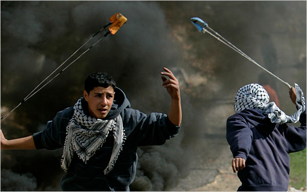 On the thirteenth day of Israel’s war against Gaza, Palestinian demonstrators use sling-shots to hurl stones at Israeli soldiers during a demonstration against Israel's military operation in Gaza, in the West Bank village of Bilin, near Ramallah, January 8, 2009.