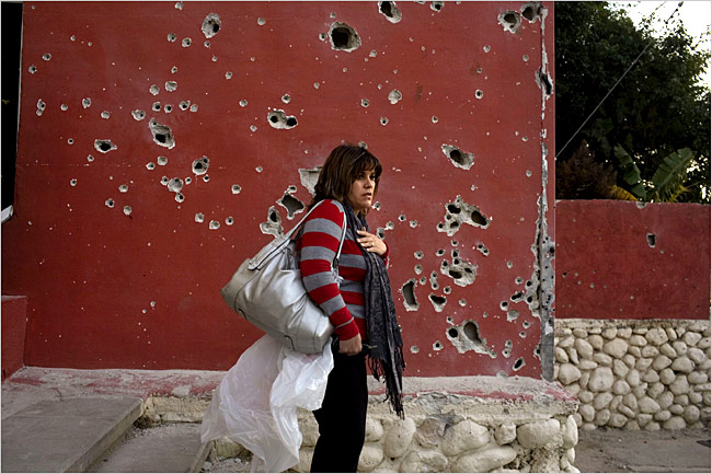 On the sixteenth day of Israel’s war against Gaza, an Israeli woman stands near a wall pockmarked by shrapnel from a Palestinian rocket, Beer Sheva, Israel, January 11, 2009.