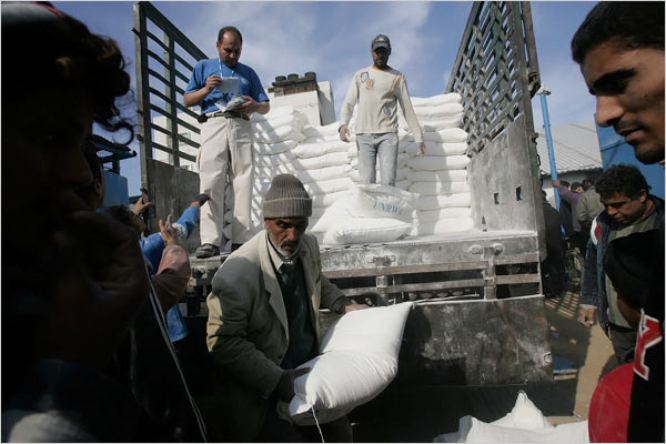 On the eighteenth day of Israel’s war against Gaza, Palestinians unload food aid from the United Nations Relief and Works Agency, al-Shati refugee camp, Gaza City, January 13, 2009.