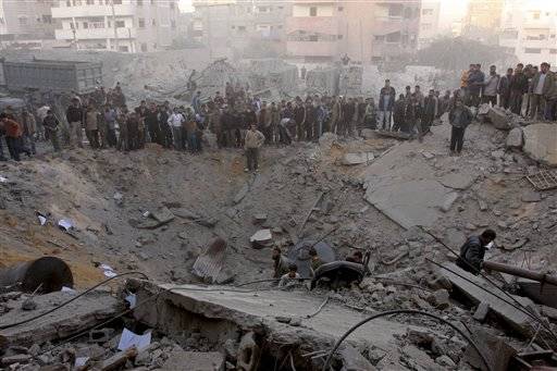 On the twentieth day of Israels war against Gaza, Palestinians gather around the crater caused by an Israeli strike which hit the house killing the top Hamas official Saeed Seyyam, Gaza City, January 15, 2009.