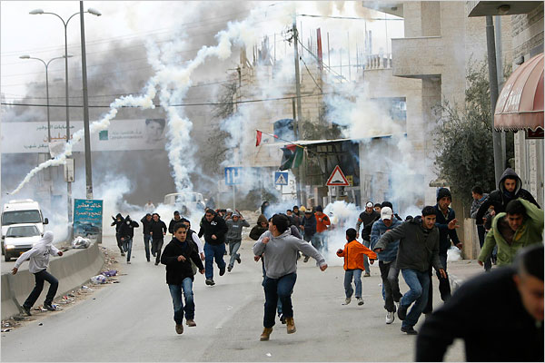 On the tweny-first day of Israel’s war against Gaza, Palestinian protesters near the West Bank city of Ramallah run from tear gas fired by Israeli border police, January 16, 2009.