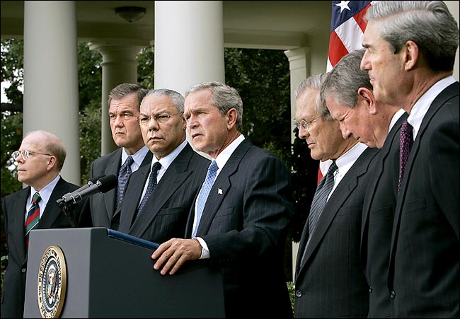President George W. Bush joined by several top cabinet officials, John McLaughlin, acting C.I.A. chief, left, Homeland Security Secretary Tom Ridge, Secretary of State Colin L. Powell, Defense Secretary Donald H. Rumsfeld, Attorney General John Ashcroft and F.B.I. Director Robert Mueller, announces his first steps in revamping intelligence, Washington, August 2, 2004.