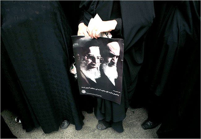 Women holdong a poster showing Iran's supreme leader Ayatollah Ali Khamenei and Ayatollah Ruhollah Khomeini listen as Khamenei leads Friday Prayer in his first public response to days of mass protests, and sternly threatens 'bloodshed' if protests continue, Tehran University, June 19, 2009.
