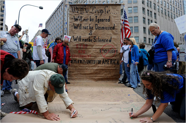 Protesters sign a huge Constitution banner in Freedom Plaza, near the White House, as hundreds of thousands of taxpayers storm Washington, D.C., to take their fight against excessive spending, bailouts, growth of big government and soaring deficits to the front door of the U.S. Capitol, September 12, 2009.