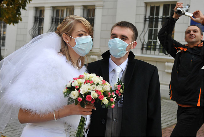 Newlyweds in masks greet guests, after the government has ordered an anti-flu crackdown, Lviv, Ukraine, October 31, 2009.